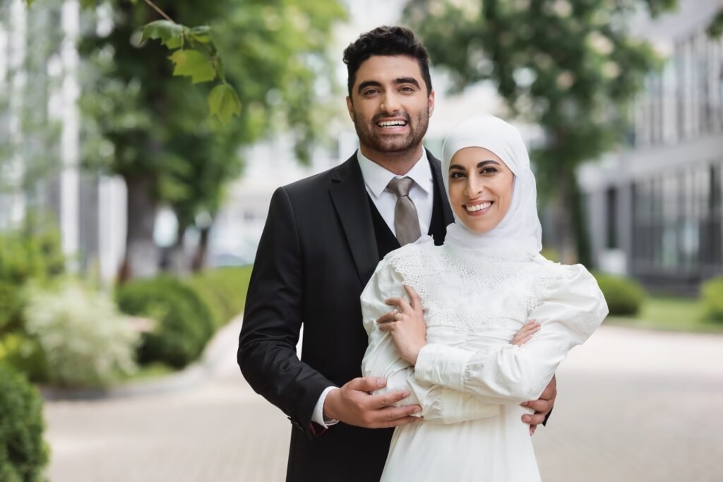 happy groom hugging muslim bride in hijab with wedding ring